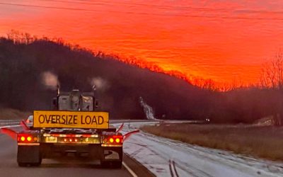 Heavy haul service truck driving off into the sunset.